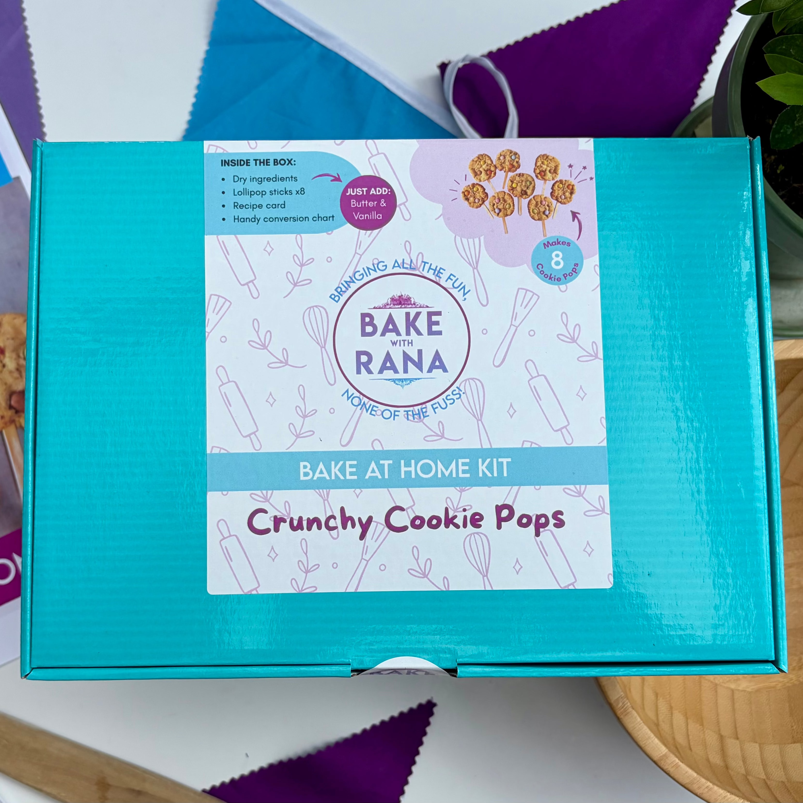 Bake At Home Kit Box on table with bunting and wooden bowl